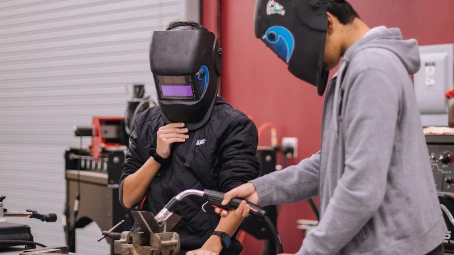 Bosch Donates Professional Sanding Tools to High School Woodworking Program: What Shoppers Should Know 2 students using power tools together